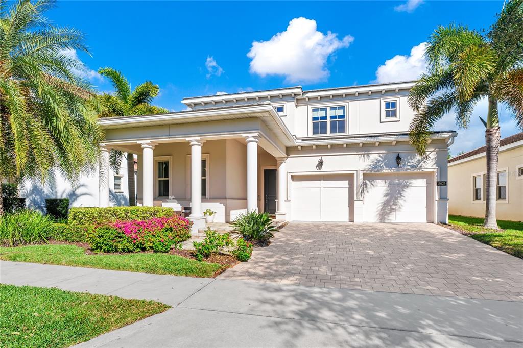 A two-story house with a covered front porch, white columns, and a paved driveway — 15625 SYLVESTER PALM DRIVE, WINTER GARDEN, FL