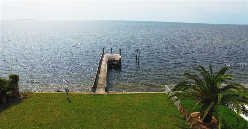 An elevated view of a wooden dock extending into a large body of water — 5141 WESTSHORE DRIVE, NEW PORT RICHEY, FL