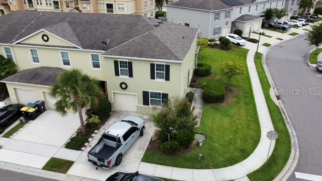 An aerial view shows a two-story townhouse with a driveway, a truck, and landscaping — 403 ARBOR LAKES DRIVE, DAVENPORT, FL