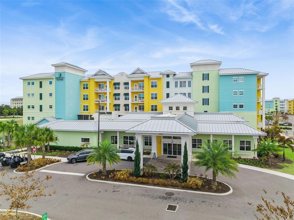 A multi-story hotel building with colorful pastel siding and a covered entrance portico — 3151 SUNSET WALK DRIVE UNIT 1214, KISSIMMEE, FL