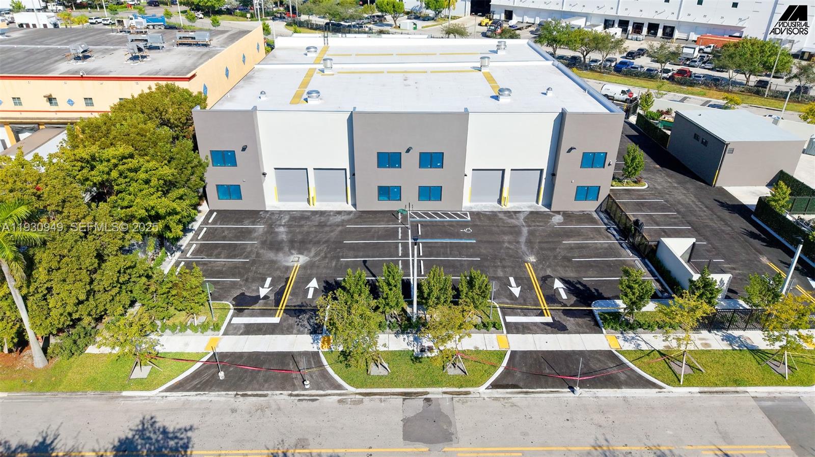 An aerial view of a modern industrial warehouse building with a paved parking lot — 10941 NW 123rd St, Medley FL 33178, MEDLEY, FL