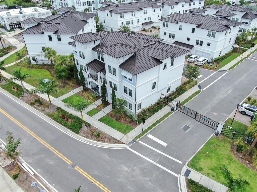 An aerial view shows a multi-story white residential building with a dark metal roof — 5351 BRIDGE STREET UNIT 16, TAMPA, FL