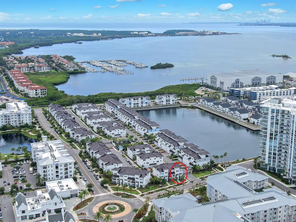 An aerial view shows a residential neighborhood with townhouses, a lake, and a marina — 5351 BRIDGE STREET UNIT 16, TAMPA, FL