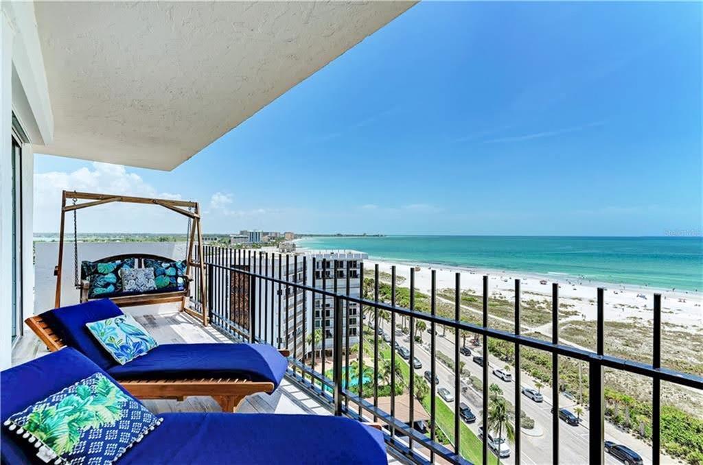 A balcony with lounge chairs and a swing overlooks a beach and the ocean — 1 BENJAMIN FRANKLIN DRIVE UNIT 3, SARASOTA, FL