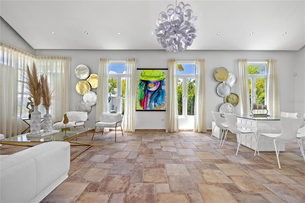 A bright living and dining area features tile floors, a modern chandelier, and colorful artwork — 35 PASEO LAS PALMAS, DORADO, PR