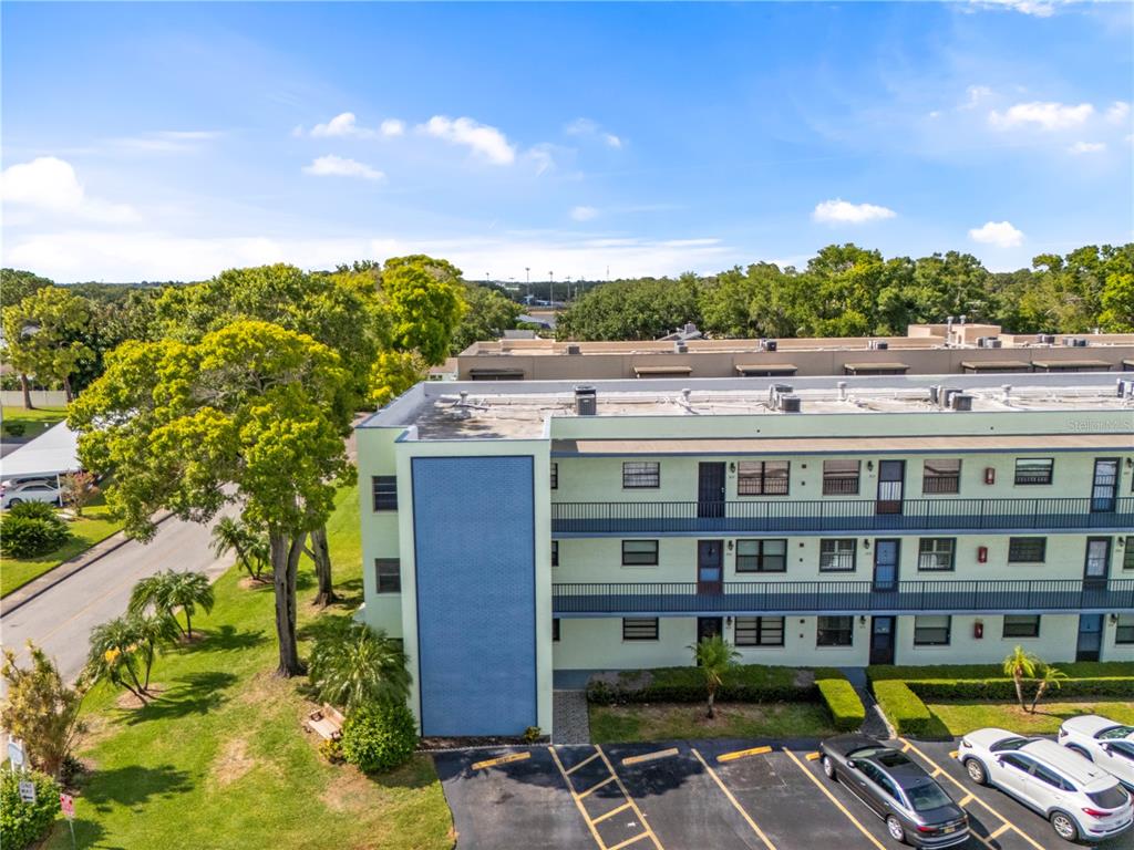An exterior view of a multi-story apartment building with a blue accent wall and parking — 5973 TERRACE PARK DRIVE N UNIT 101, ST PETERSBURG, FL