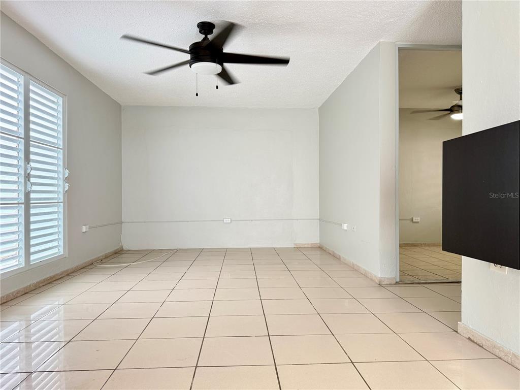 A room with light-colored floor tiles, a ceiling fan, and white walls — 143 JARDINES DE COUNTRY CLUB UNIT CG26, CAROLINA, PR