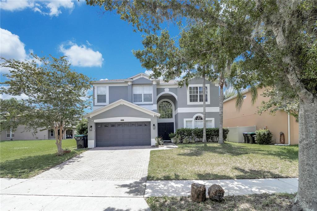 A two-story gray house with a two-car garage and a paved driveway — 13051 MOSS PARK RIDGE DRIVE, ORLANDO, FL