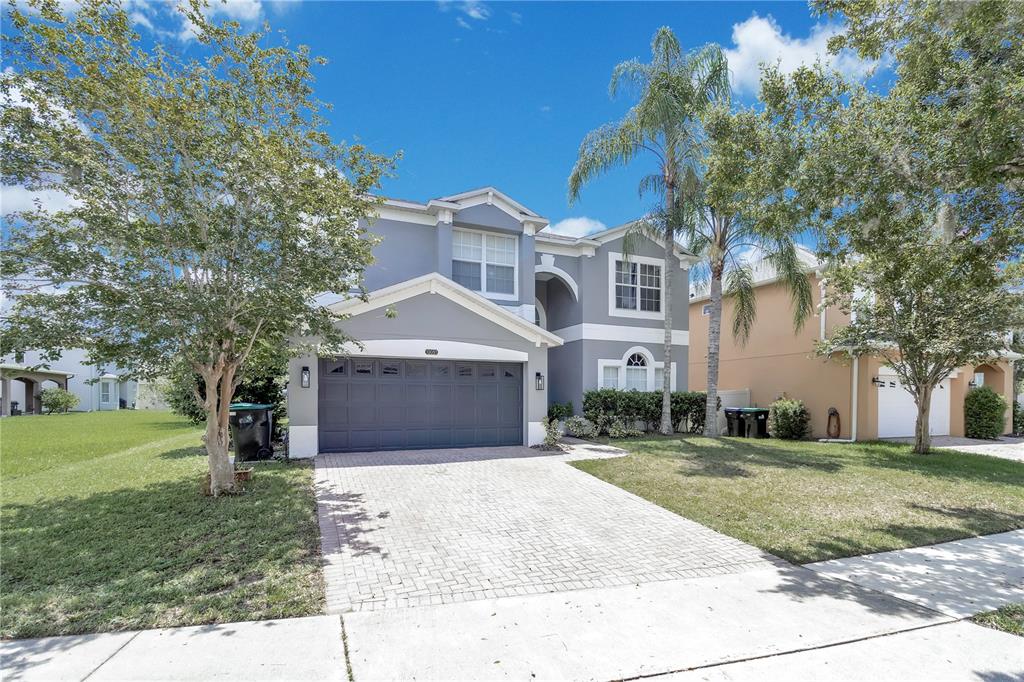 A two-story gray house with a paved driveway and a two-car garage — 13051 MOSS PARK RIDGE DRIVE, ORLANDO, FL