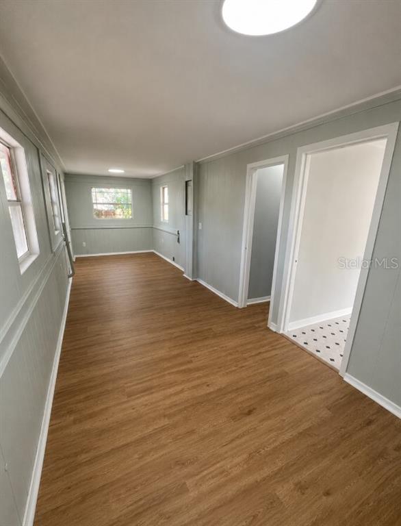 An interior view of a room with light gray walls, wood-look flooring, and two doorways — 837 LAFAYETTE LANE, LAKELAND, FL