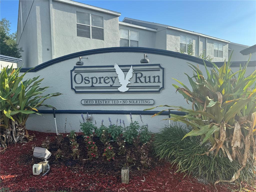 A sign for the Osprey Run community stands in front of a multi-story residential building — 6229 OSPREY LAKE CIRCLE, RIVERVIEW, FL