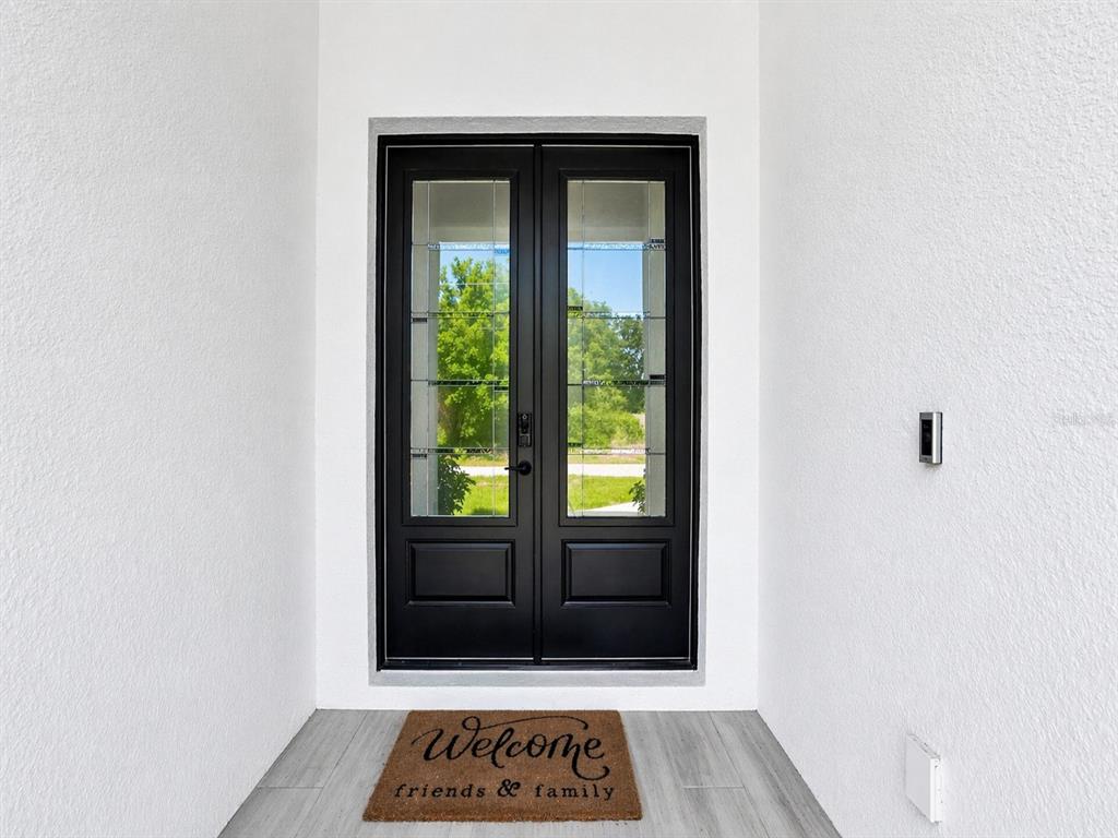 A black double front door with glass panels sits under a white entryway — 3090 QUARTER STREET, NORTH PORT, FL