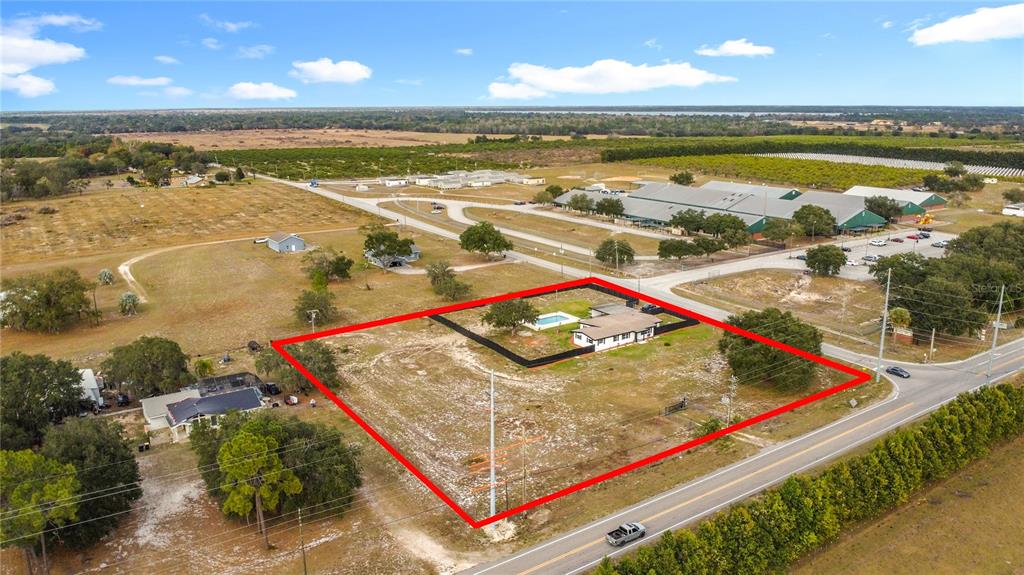 An aerial view shows a house with a pool on a large, fenced-in rural lot — 1890 TYNER ROAD, HAINES CITY, FL