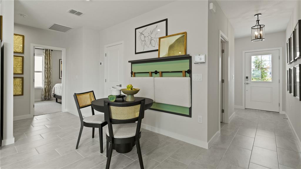 A small dining area with a round table and two chairs sits near an entryway — 1952 DIAMOND HEAD CIRCLE, HAINES CITY, FL