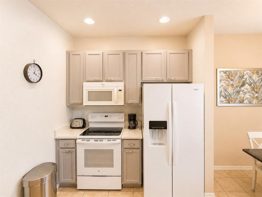 A kitchen features light gray cabinets, white appliances, and a stainless steel trash can — 2379 CARAVELLE CIRCLE, KISSIMMEE, FL