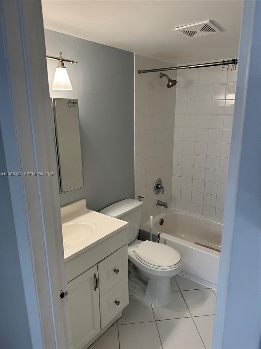 A bathroom features a white vanity, a toilet, and a shower-tub combination with white tiles — 8075 NW 7th St # 403, Miami FL 33126, MIAMI, FL