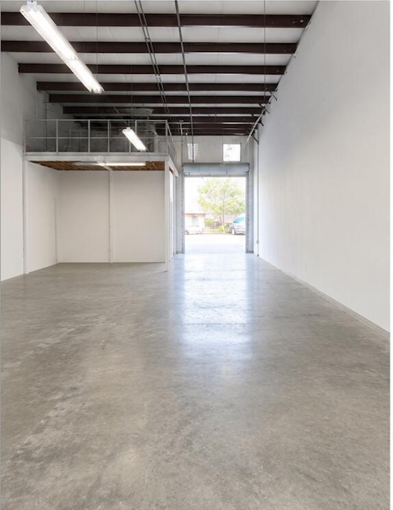 An empty industrial warehouse space features a concrete floor, white walls, and a metal mezzanine — 2150 Anntom Drive # 5, Dania Beach FL 33312, DANIA BEACH, FL
