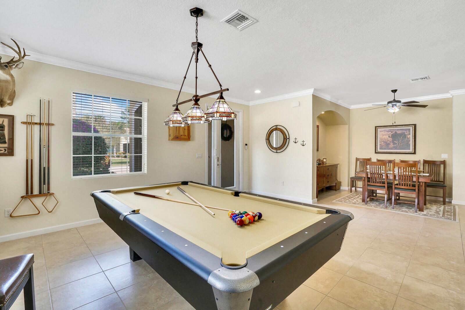A game room features a pool table, a dining area, and neutral tile flooring — 9328 Silent Oak Circle, West Palm Beach FL 33411, WEST PALM BEACH, FL