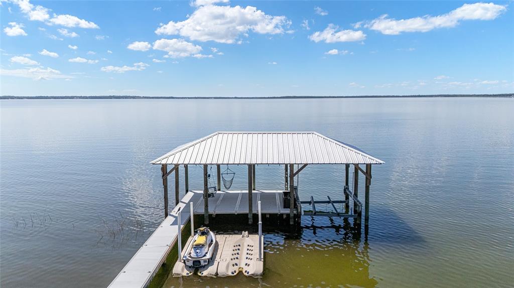 An aerial view shows a long wooden dock extending into a lake from a beach — 12830 SE 144TH AVENUE, OCKLAWAHA, FL
