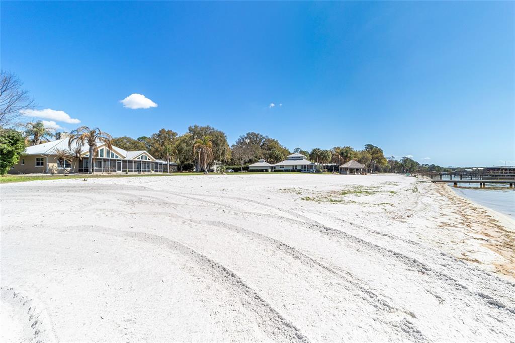 An exterior view of a house with a metal roof and a large screened-in porch — 12830 SE 144TH AVENUE, OCKLAWAHA, FL