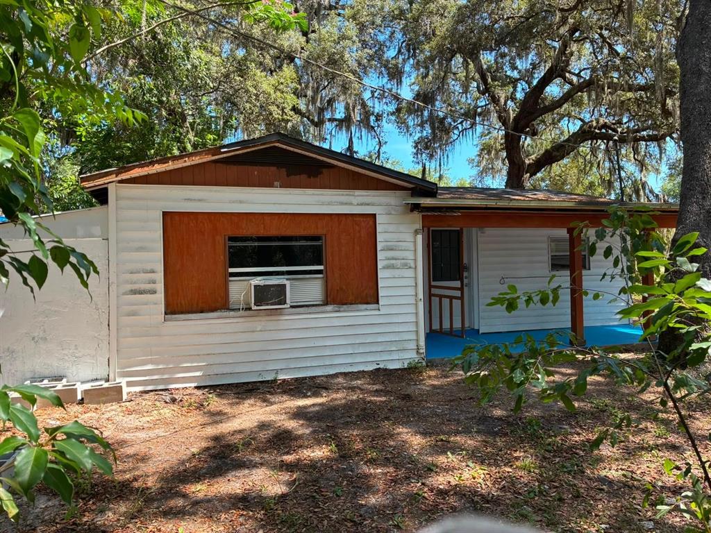 A single-story house with white siding, a wooden window surround, and a covered front porch — 106 PENNSYLVANIA AVENUE, POMONA PARK, FL