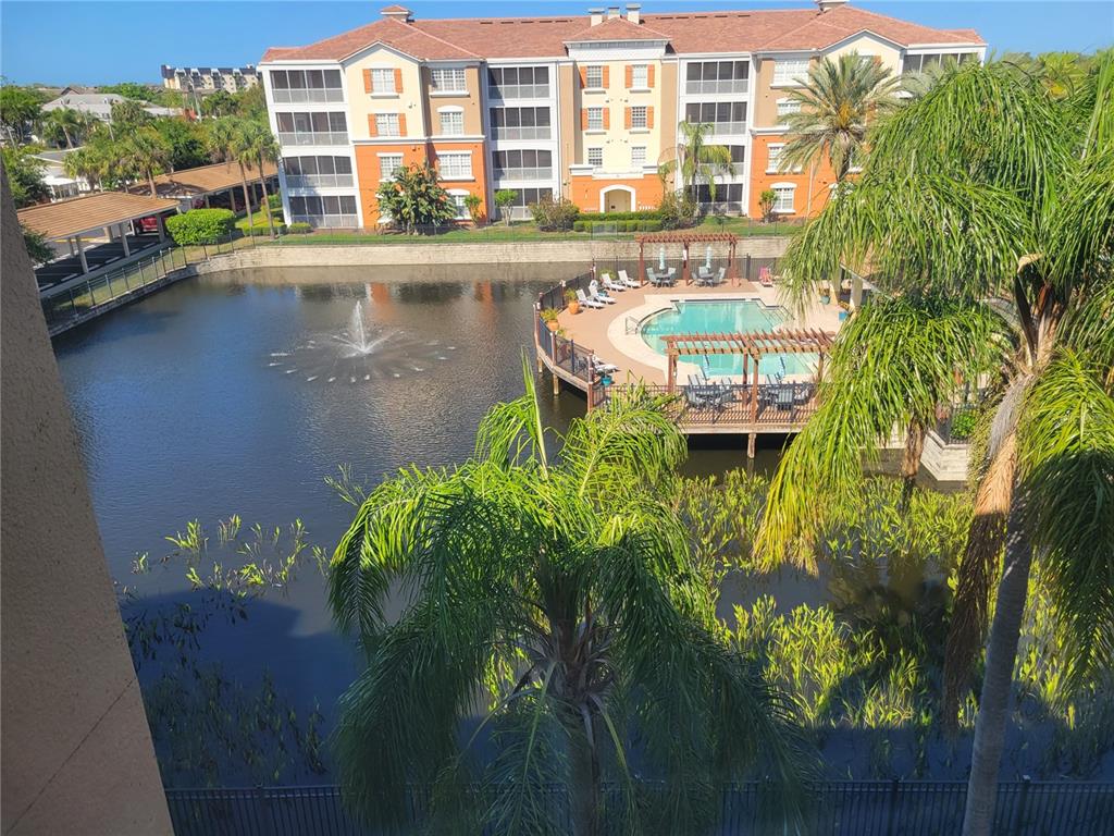 An elevated view of a pond with a fountain, a swimming pool, and apartment buildings — 7905 N SEMINOLE BOULEVARD UNIT 3404, SEMINOLE, FL