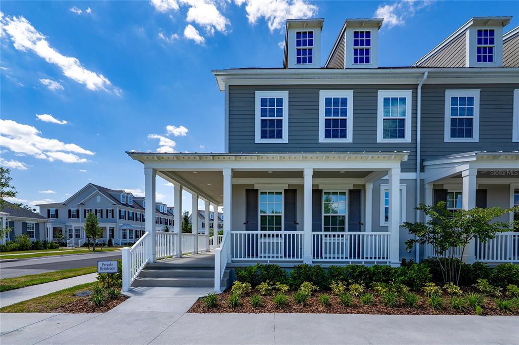 A gray two-story house features a covered front porch with white railings and columns — 2426 CELEBRATION BOULEVARD, KISSIMMEE, FL