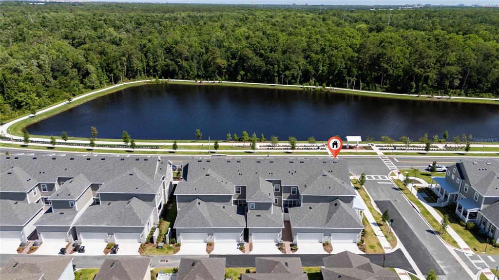 An aerial view shows a row of townhouses situated next to a large pond — 2426 CELEBRATION BOULEVARD, KISSIMMEE, FL
