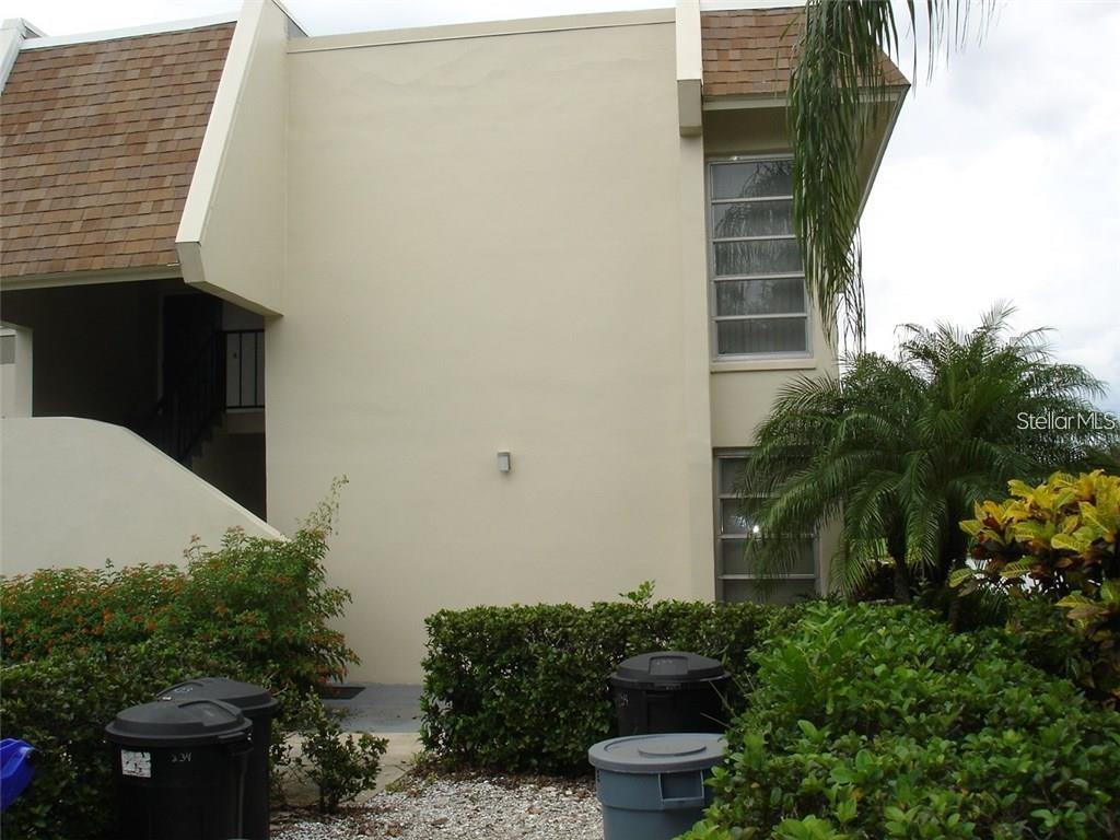 Exterior view of a two-story building with tan stucco walls and a shingled roof — 7211 W COUNTRY CLUB DRIVE N UNIT 133, SARASOTA, FL
