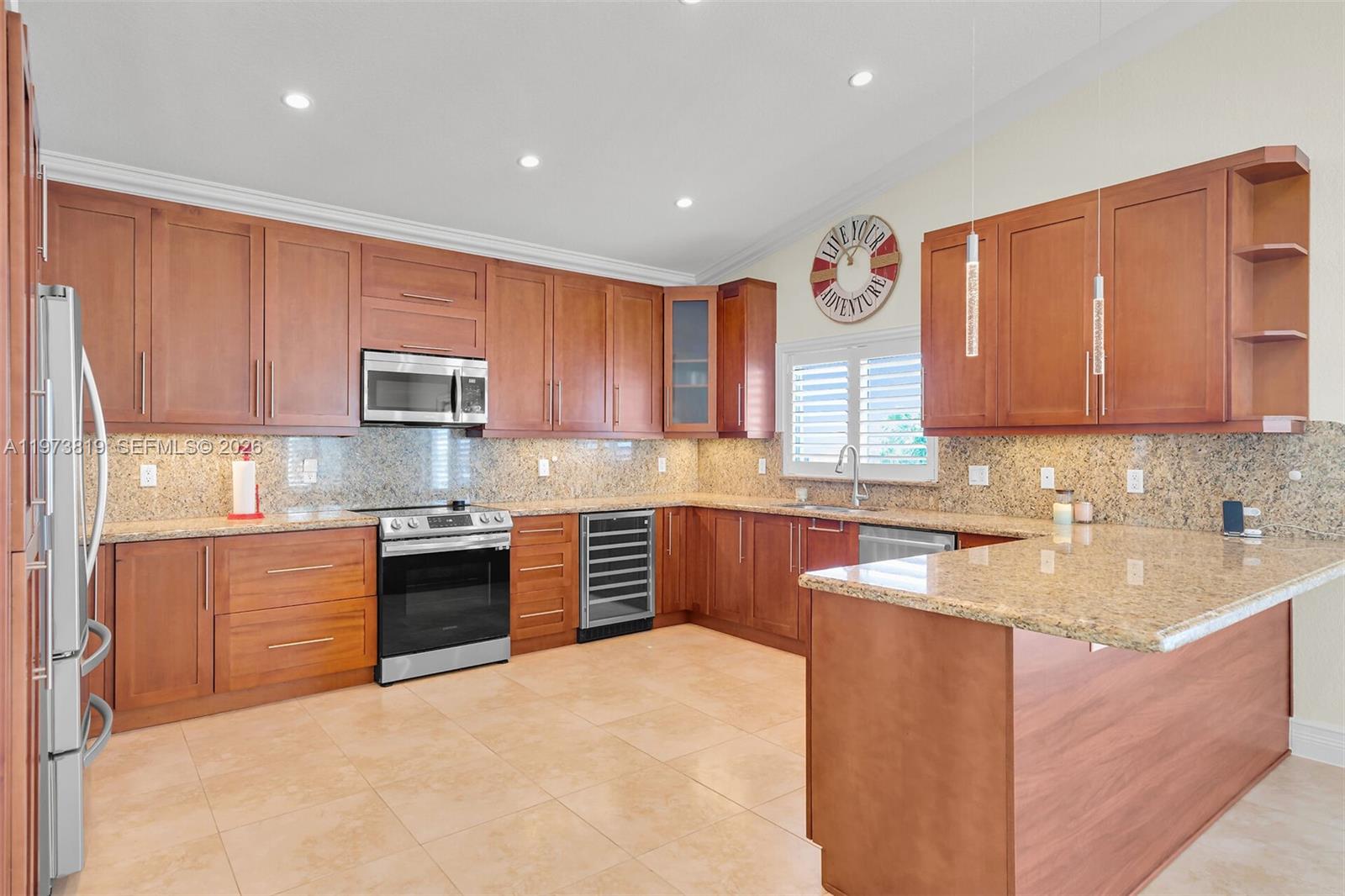 A kitchen features wood cabinets, granite countertops, stainless steel appliances, and tile flooring — 226 Normandy Dr, Tavernier FL 33070, TAVERNIER, FL