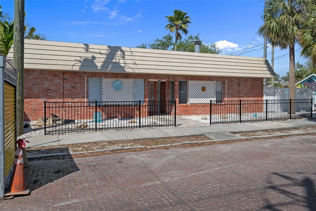 A single-story brick building with a wide, sloped roof and a black metal fence — 5437 29TH AVENUE S, GULFPORT, FL