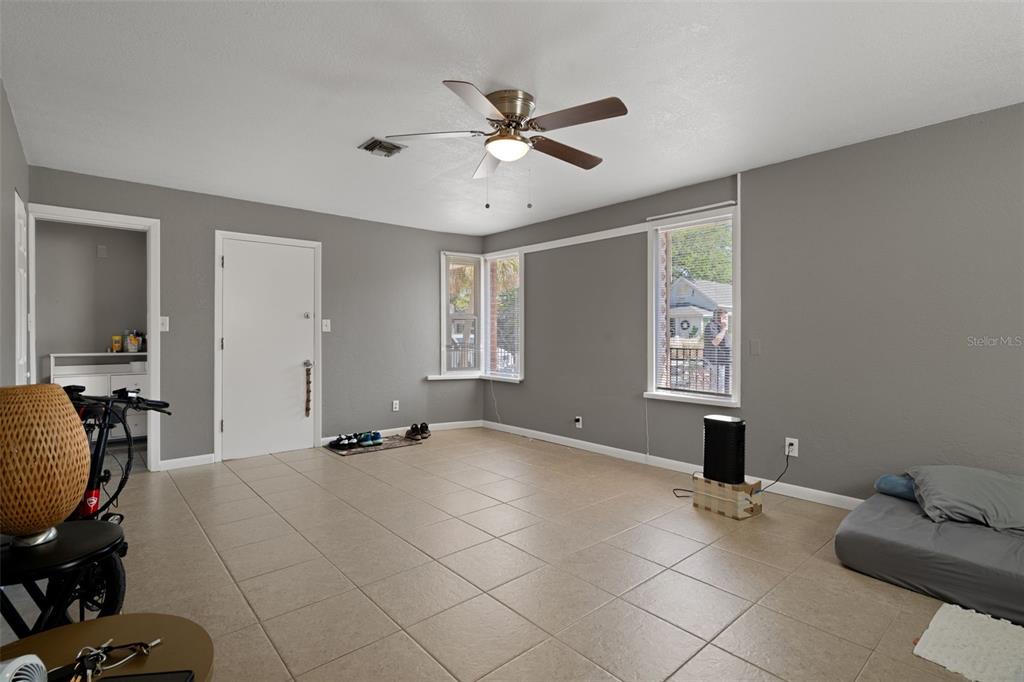 A living room with gray walls, tile flooring, a ceiling fan, and two windows — 5437 29TH AVENUE S, GULFPORT, FL