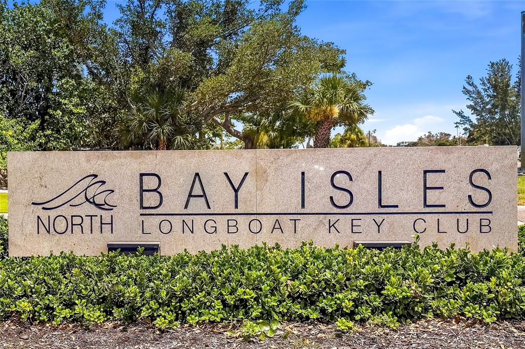 A stone monument sign displays the name Bay Isles North Longboat Key Club — 3526 FAIR OAKS LANE, LONGBOAT KEY, FL