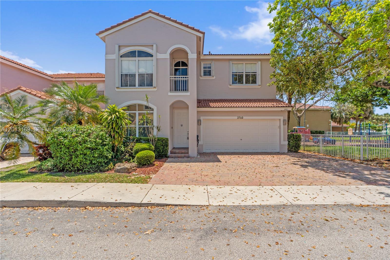 A two-story suburban house features a brick driveway, a garage, and a small balcony — 3760 SW 51st St, Hollywood FL 33312, HOLLYWOOD, FL