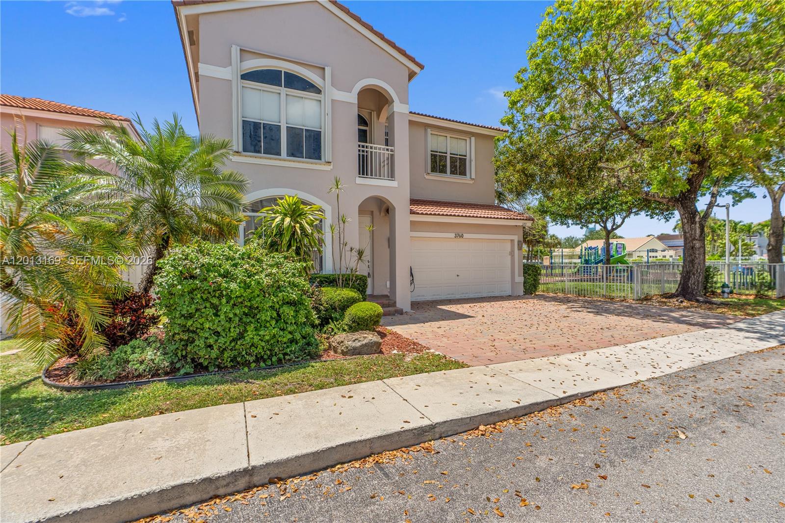 A two-story stucco house with a tiled roof, brick driveway, and adjacent playground — 3760 SW 51st St, Hollywood FL 33312, HOLLYWOOD, FL