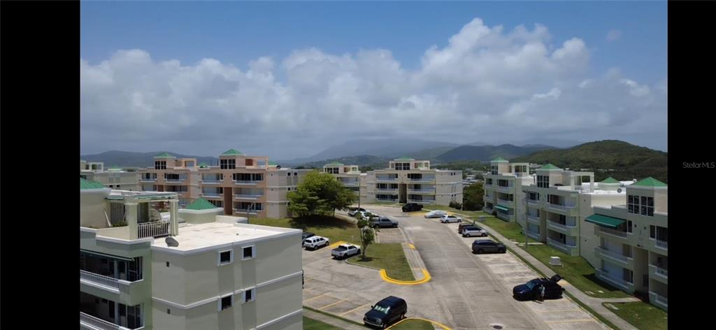 An elevated view of a multi-building apartment complex with parking lots and surrounding hills — Cond Vista Real E 3 -23 -B VILLAGE E UNIT 23, FAJARDO, PR