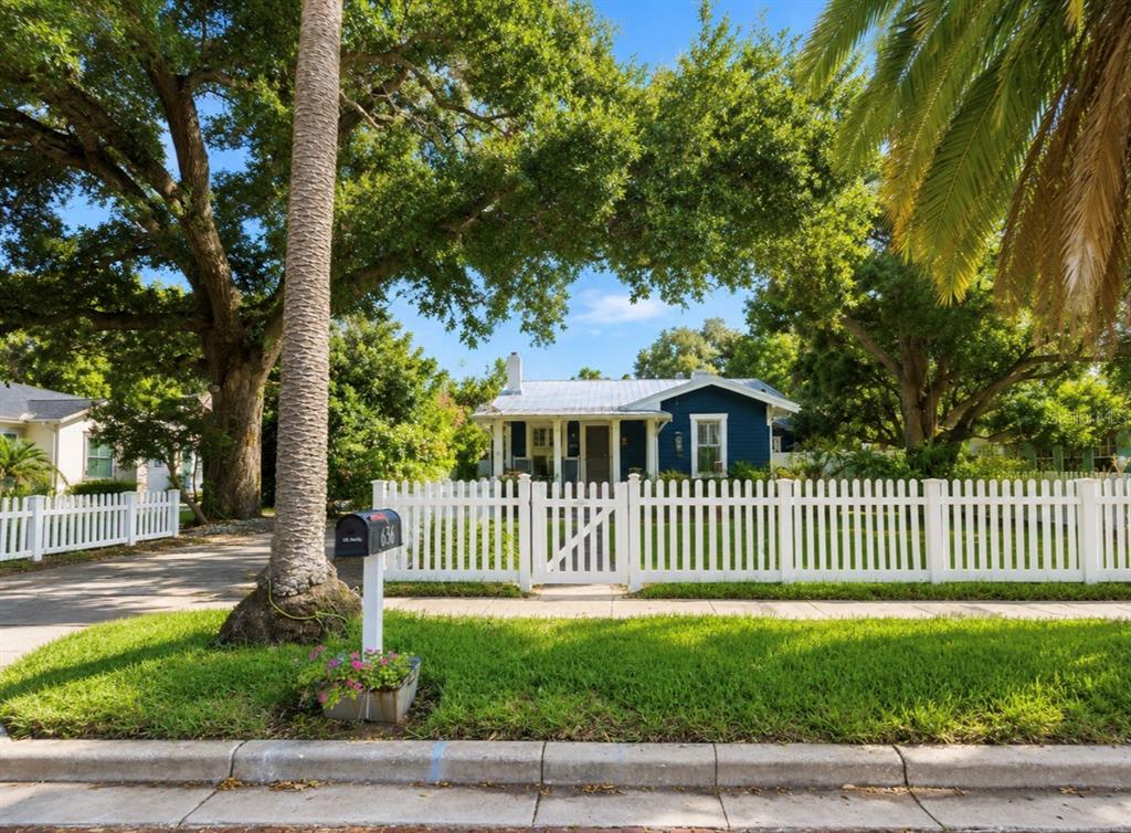 A backyard features a swimming pool with an attached hot tub and a tiki bar — 636 WILKIE STREET, DUNEDIN, FL
