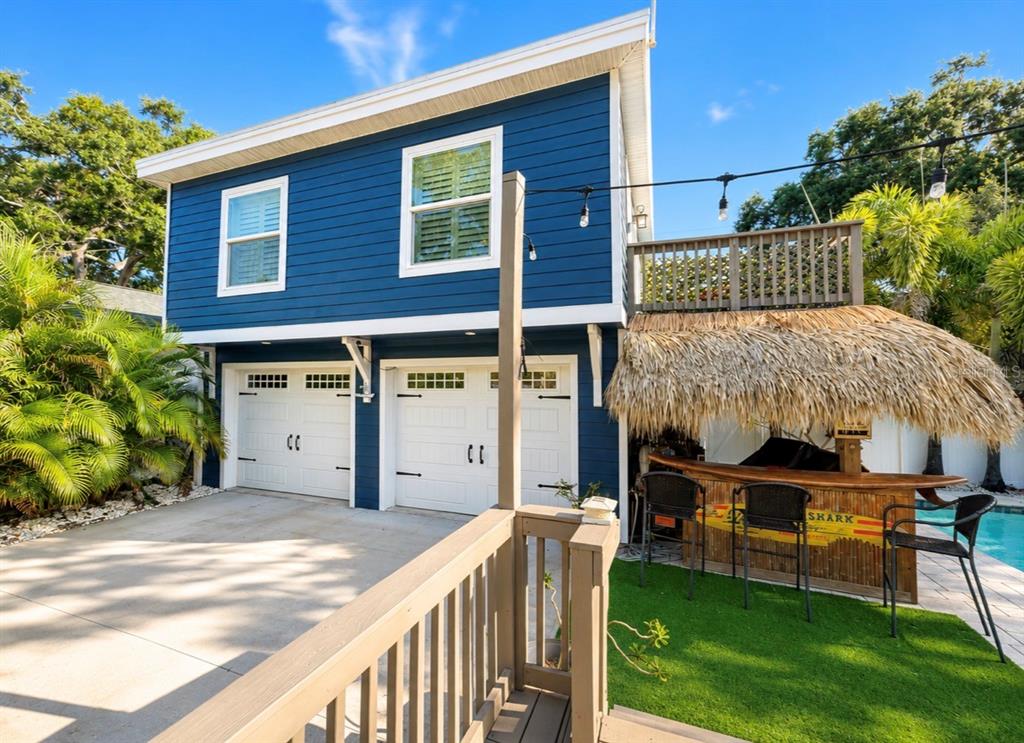 An aerial view shows a blue two-story garage, a swimming pool, and a wooden deck — 636 WILKIE STREET, DUNEDIN, FL