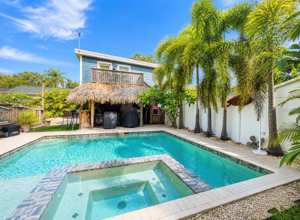 A kitchen features white cabinets, a farmhouse sink, stainless steel appliances, and stained-glass windows — 636 WILKIE STREET, DUNEDIN, FL