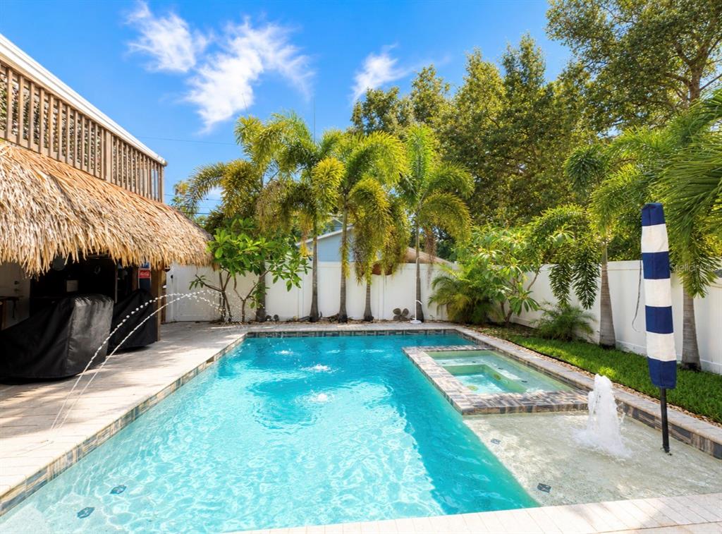 A living room features a white brick fireplace, dark wood floors, and a ceiling fan — 636 WILKIE STREET, DUNEDIN, FL