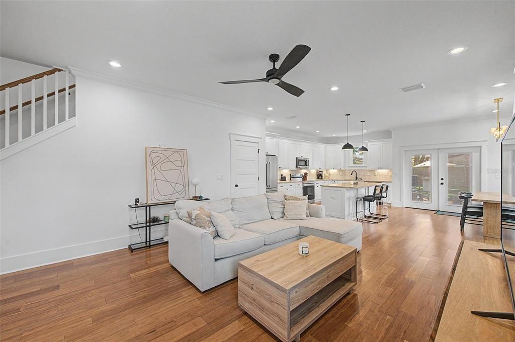 A bright open-concept living room features hardwood floors, a sectional sofa, and a kitchen island — 911 E OSBORNE AVENUE UNIT A, TAMPA, FL