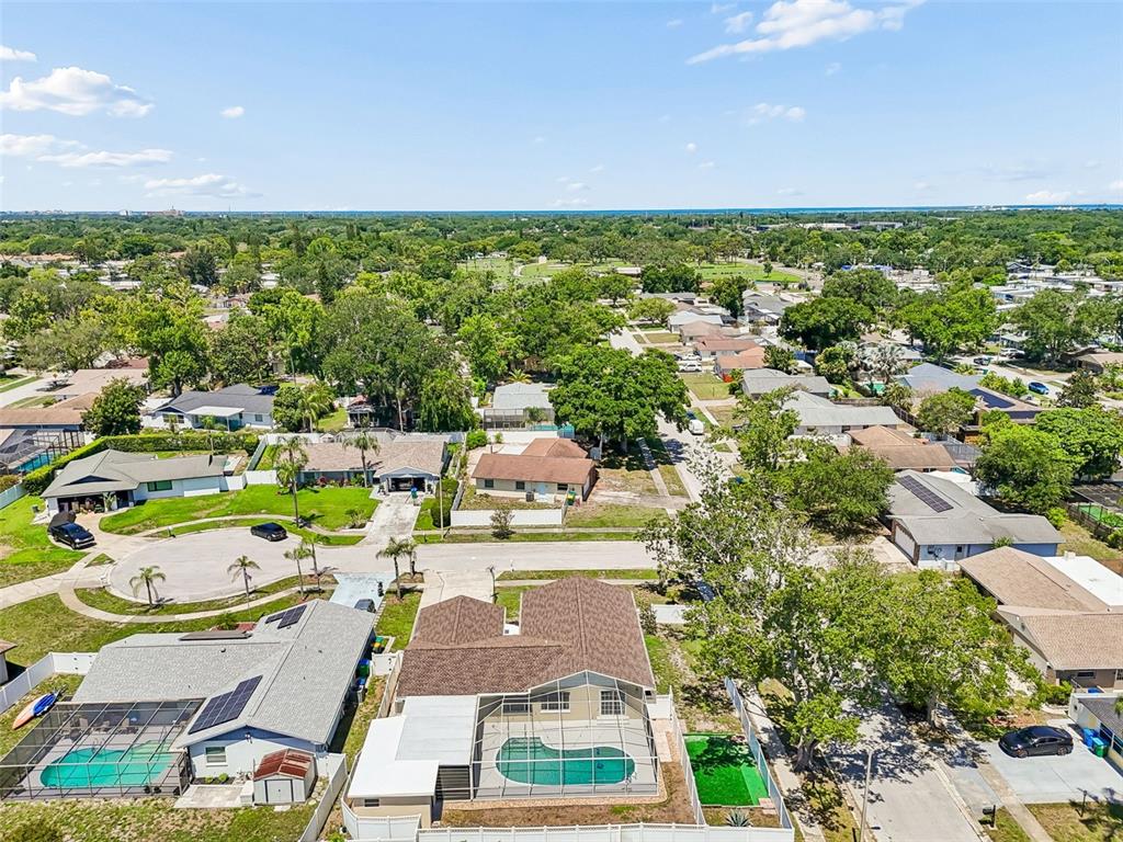 An aerial view shows a house with a brown roof, a pool cage, and a driveway — 2959 MAPLE COURT, DUNEDIN, FL
