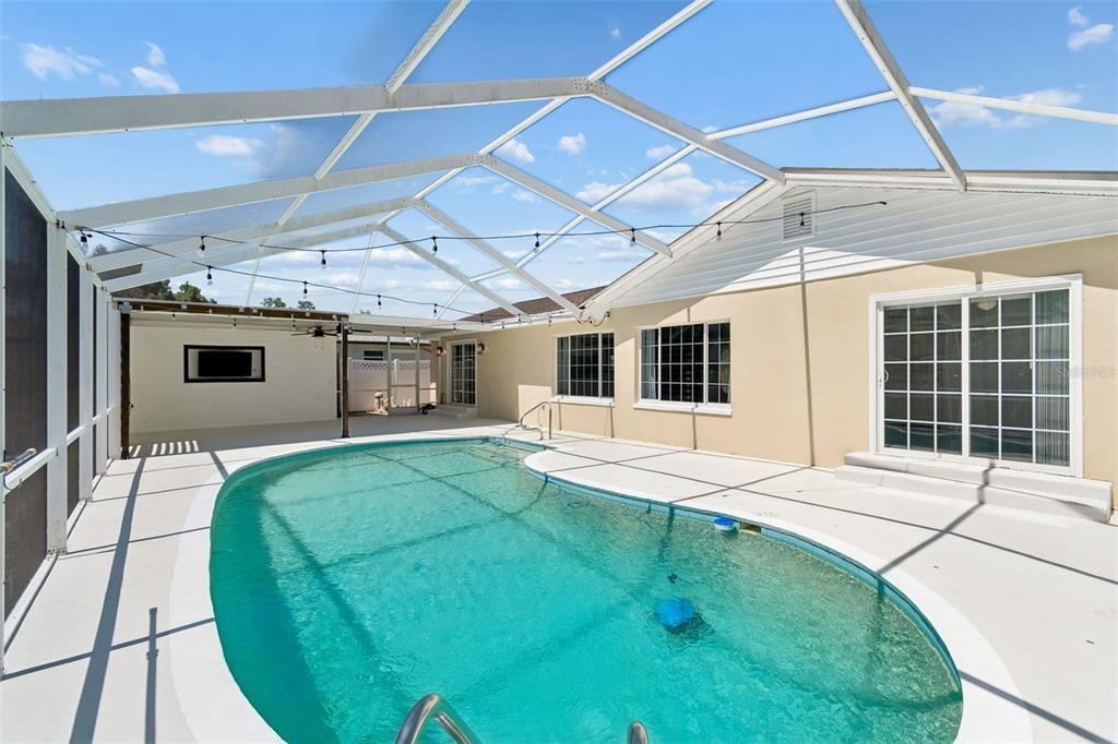 A single-story house with a beige exterior, white garage door, and a concrete driveway — 2959 MAPLE COURT, DUNEDIN, FL