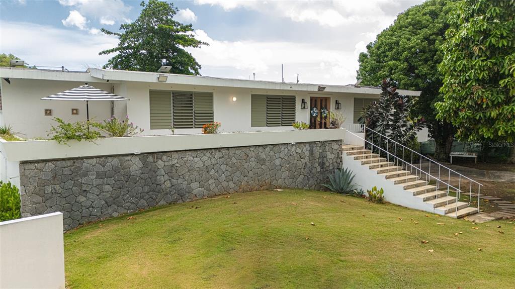 A white house with a stone retaining wall and stairs leading to the front entrance — CARR. 686 KM 1.5 BO. TIERRAS NUEVAS SALIENTES, MANATI, PR