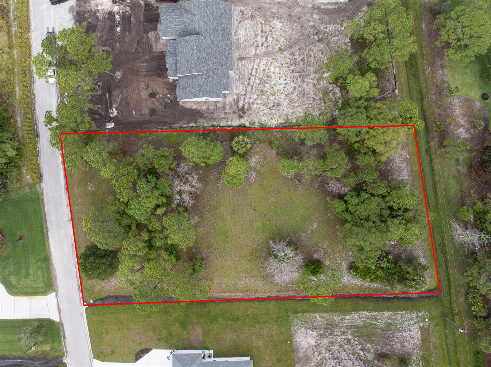 An aerial view shows a rectangular vacant lot outlined in red, surrounded by trees — 10638 Sugar Pine Drive, Fort Pierce FL 34945, FORT PIERCE, FL
