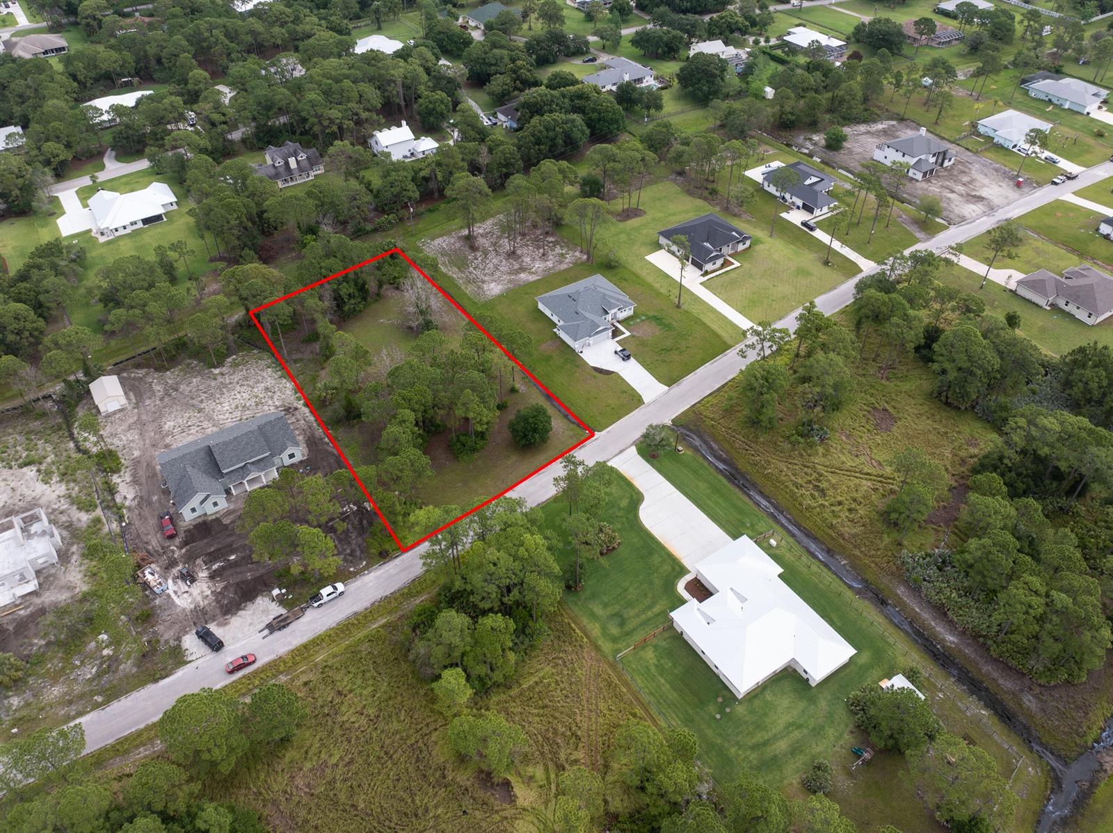 An aerial view shows a vacant, rectangular lot outlined in red within a residential neighborhood — 10638 Sugar Pine Drive, Fort Pierce FL 34945, FORT PIERCE, FL