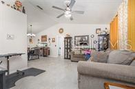 A living room with light tile flooring, a ceiling fan, and a view into the kitchen — 630 HOBSON TERRACE, DELTONA, FL
