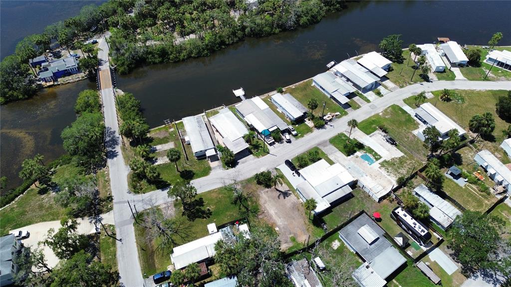 An aerial view shows a residential neighborhood with mobile homes situated along a narrow waterway — 6828 EDGEWATER DRIVE, NEW PORT RICHEY, FL