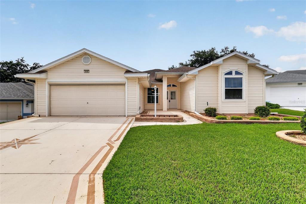 A single-story house with beige siding, a two-car garage, and a front lawn — 4808 KILT COURT, LEESBURG, FL
