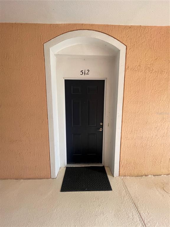 A black front door with the number 512 is set within an arched white frame — 13536 TURTLE MARSH LOOP UNIT 512, ORLANDO, FL